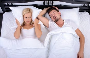 Young woman can not sleep through the snoring of her husband in her bedroom