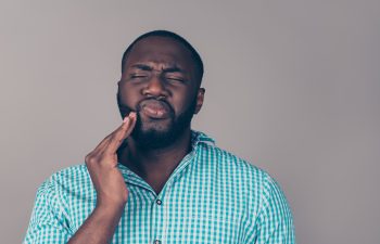Portrait of bearded afroamerican man touch cheek. He have strong tooth ache