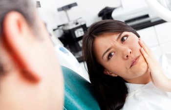 Woman at the dentist complaining about a tooth pain