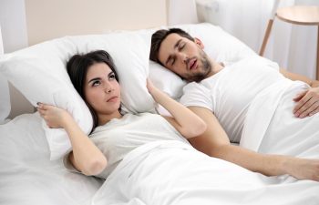 Young girl can't sleep because of her man's snoring.