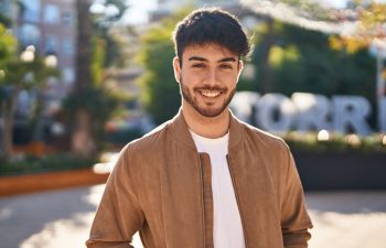 Young hispanic man smiling confident standing at park