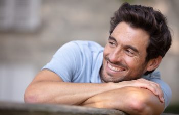young man relaxing on park bench on a summers day